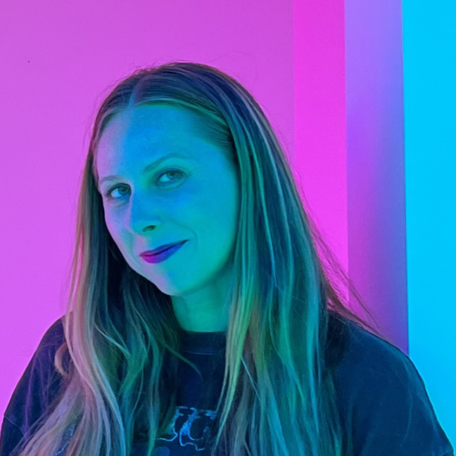 Carrie at the Color Factory, her skintone is bright electric blue from the lights in the room